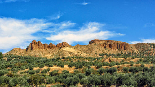 Scenic view of rocky mountains against blue sky in frigiliana, granada