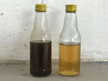 Close-up of beer glass on table against wall