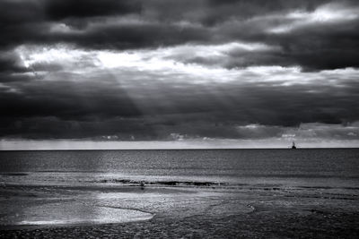 Scenic view of calm sea against cloudy sky