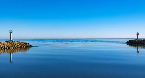 Scenic view of sea against clear blue sky during sunset