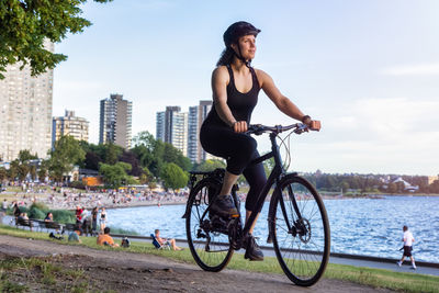 Man riding bicycle on river against sky