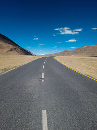 Road by mountain against sky