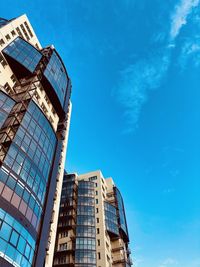 Low angle view of modern building against blue sky