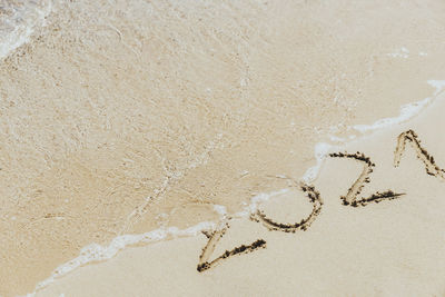 High angle view of text on sand at beach