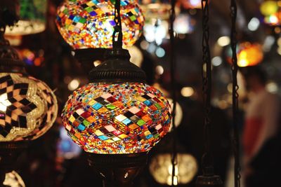 Close-up of illuminated lighting equipment hanging at market stall