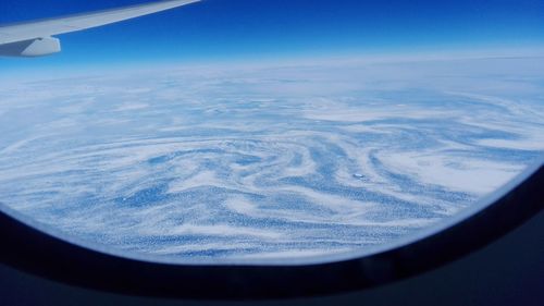 Cropped image of airplane wing over landscape