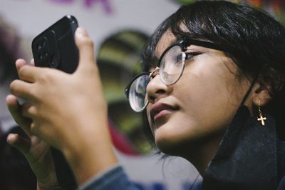 A cute young girl smile whlie reading the text on her smartphone