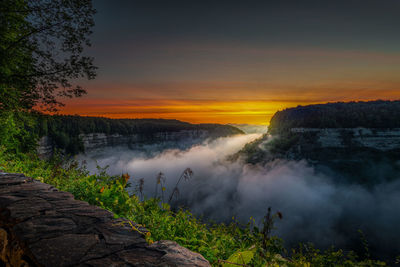 Scenic view of waterfall against sky during sunset