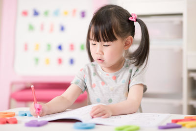 Young girl practice writing letters for homeschooling