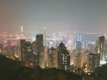 Illuminated buildings in city against sky at night