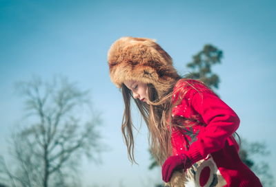 Side view of woman against sky during winter