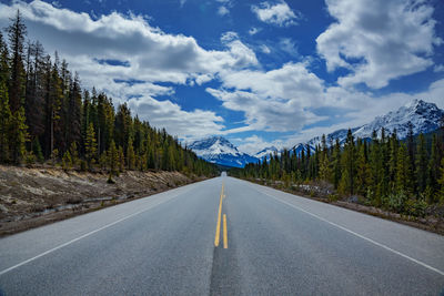 Rear view of man walking on road against sky