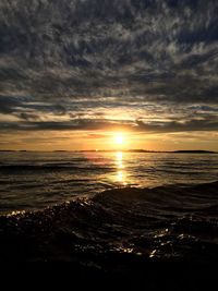 Scenic view of sea against dramatic sky during sunset