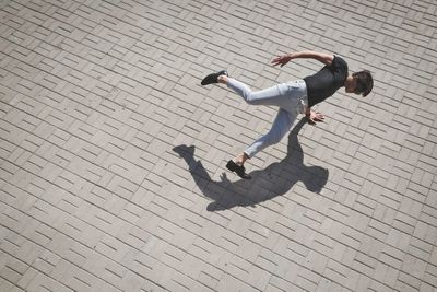 High angle view of young man doing handstand on street