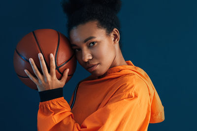 Midsection of woman holding basketball