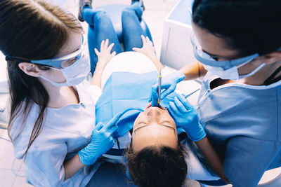 Dentists examining pregnant woman in clinic