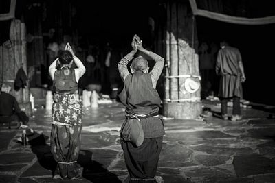 Rear view of people praying at temple