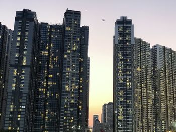 Low angle view of illuminated buildings against sky in city