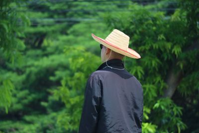 Rear view of man standing against trees