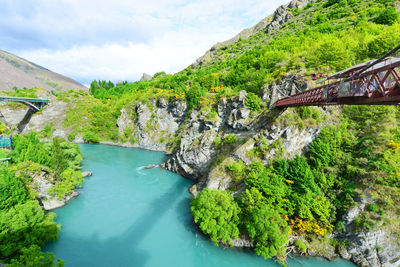 Scenic view of river by mountains against sky