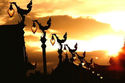 Low angle view of silhouette plants against orange sky