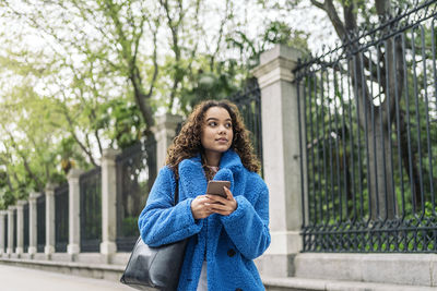 Young woman using mobile phone in city