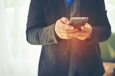 Midsection of man using mobile phone