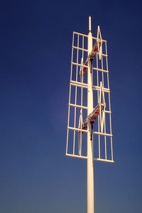 Low angle view of antenna against clear blue sky