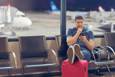 Portrait of man sitting on chair at airport