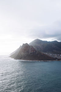 Scenic view of sea and mountains against sky