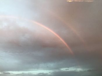 Low angle view of rainbow against sky during sunset