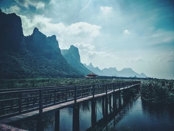 Scenic view of river by mountains against sky