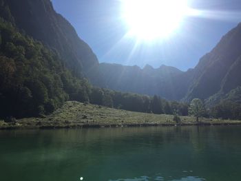 Scenic view of river by mountains against sky
