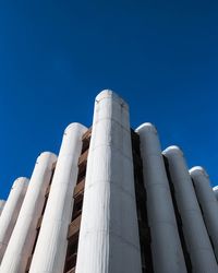 Low angle view of factory against clear blue sky