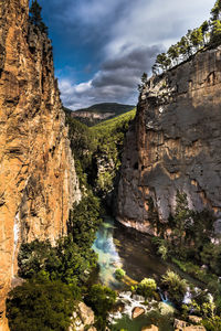 Scenic view of rock formation amidst trees against sky