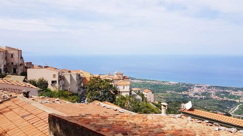 High angle view of buildings by sea against sky