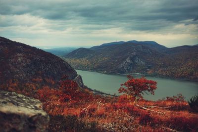 Scenic view of lake by mountains against sky