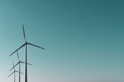 Low angle view of windmill against clear blue sky