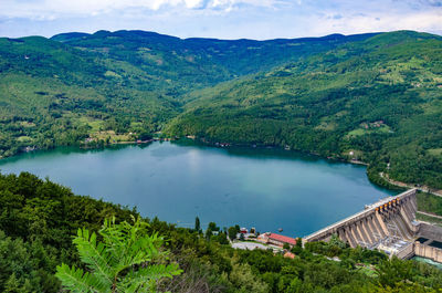 High angle view of lake amidst trees against sky