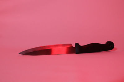 Close-up of pink cake on table against colored background