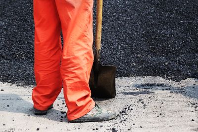 Low section of man standing on road at construction site