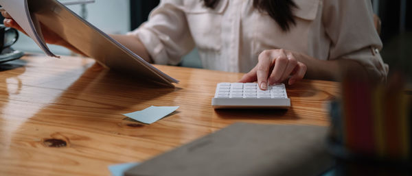 Midsection of woman working on table