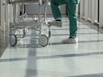 Low section of nurse with cart in corridor