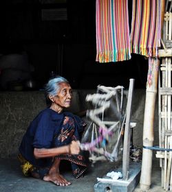 Side view of woman sitting at home