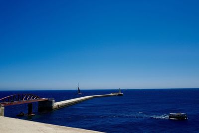 Scenic view of sea against clear blue sky