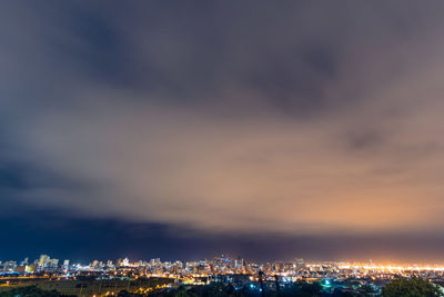 Illuminated buildings against sky at night