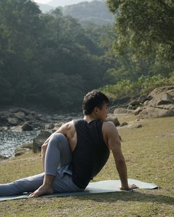 Side view of woman sitting on rock