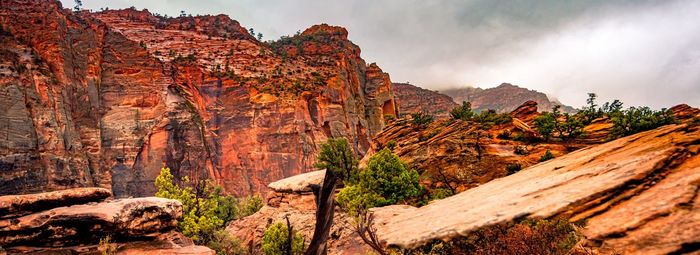 Rock formations on mountain against cloudy sky