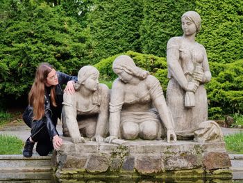 Sculpture of washng women in pond with posing woman