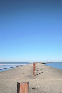 Scenic view of beach against clear blue sky